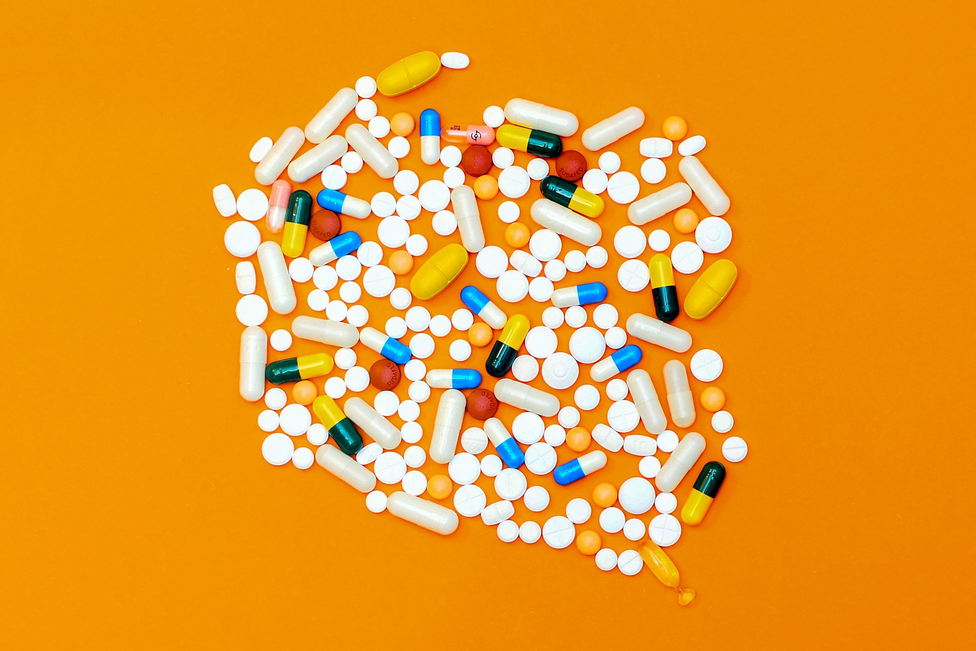 Vitamin supplements laying on an orange table